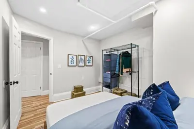 a bedroom with a bed with blue pillows at Newly Renovated 2BR w Rare Private Backyard and BBQ in New York