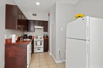 a kitchen with brown cabinets and a white refrigerator at Cozy 1BR w Deck Near Rittenhouse in Philadelphia