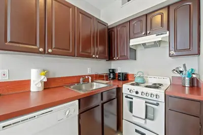 a kitchen with wooden cabinets and a sink and a stove at Cozy 1BR w Deck Near Rittenhouse in Philadelphia