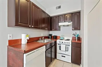 a kitchen with wooden cabinets and a white stove top oven at Cozy 1BR w Deck Near Rittenhouse in Philadelphia