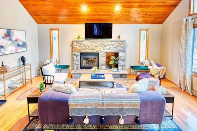 a living room with a large bed and a fireplace at Antler Ridge: 3BDR w Hot Tub & Game Room in Albrightsville
