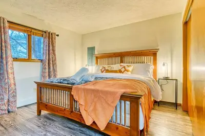 a bedroom with a large bed and a window at Antler Ridge: 3BDR w Hot Tub & Game Room in Albrightsville