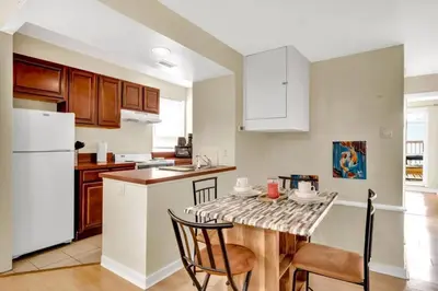 a kitchen with a table with chairs and a white refrigerator at Stylish 1BR Prime Location in Philadelphia
