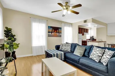a living room with a blue couch and a ceiling fan at Stylish 1BR Prime Location in Philadelphia