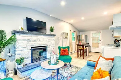 a living room with a blue couch and a fireplace at Hot Tub Fire Pit Dog Friendly in Pocono Lake