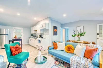 a living room with a blue couch and a kitchen at Hot Tub Fire Pit Dog Friendly in Pocono Lake
