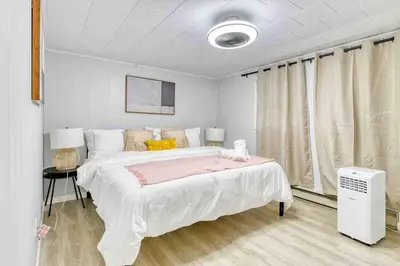 a white bedroom with a large bed and a window at Hot Tub Fire Pit Dog Friendly in Pocono Lake