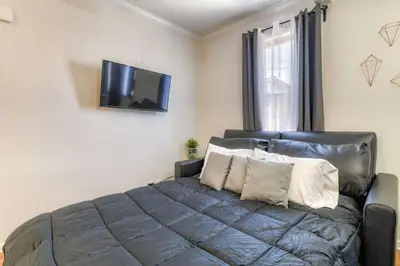 a bedroom with a bed and a flat screen tv at Modern 3BR2BA Apartment Minutes to NYC in Jersey City