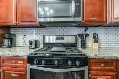 a kitchen with a stove and a microwave at Modern 3BR2BA Apartment Minutes to NYC in Jersey City