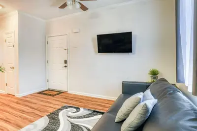a living room with a couch and a flat screen tv at Modern 3BR2BA Apartment Minutes to NYC in Jersey City