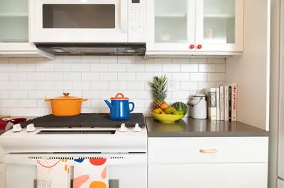 a kitchen with white cabinets and a stove top oven at The Suites at the Touraine No 109 in Philadelphia