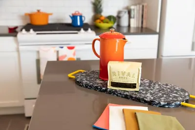 a kitchen counter with an orange tea pot on a table at The Suites at the Touraine No 109 in Philadelphia