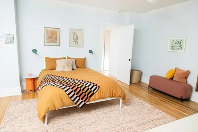 a bedroom with a bed with an orange blanket at The Suites at the Touraine No 109 in Philadelphia