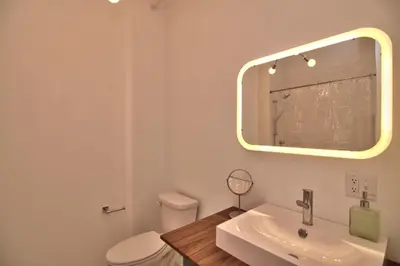 a bathroom with a toilet and a sink and a mirror at Wonder Loft A3 - Main St. Honesdale in Honesdale