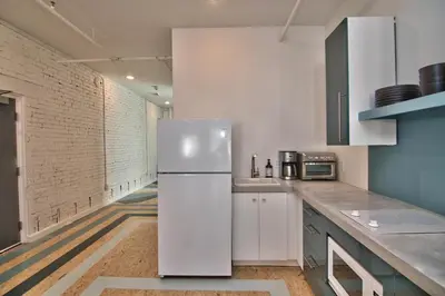 a kitchen with a white refrigerator and a brick wall at Wonder Loft A3 - Main St. Honesdale in Honesdale
