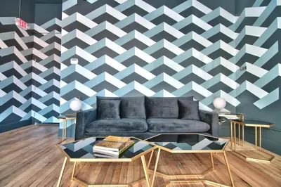 a living room with a couch and a geometric wall at Wonder Loft A3 - Main St. Honesdale in Honesdale