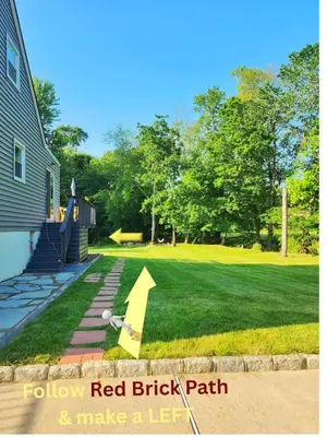 a yard with a red brick path and make a left sign at Starlight Guesthouse in West Orange