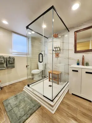 a glass shower in a bathroom with a toilet at Starlight Guesthouse in West Orange