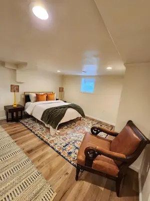 a bedroom with a bed and a chair at Starlight Guesthouse in West Orange