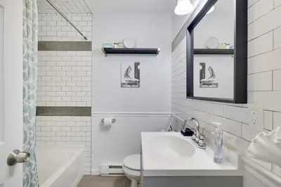 a bathroom with a sink and a toilet and a mirror at Nature’s Haven:4 br/2.5 bath, game room & Fire pit in Tobyhanna