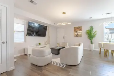 a white living room with white chairs and a table at Modern one bedroom apartment in Elizabeth