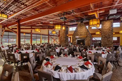 a large banquet hall with white tables and chairs at Bear Creek Mountain Resort in Breinigsville