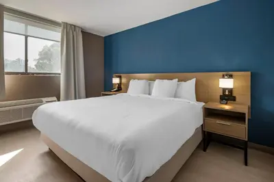 a large bed in a hotel room with a blue wall at Comfort Inn Philadelphia International Airport West in Chester