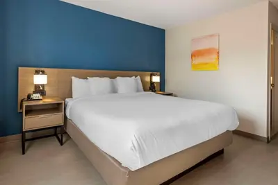 a bedroom with a large white bed and a blue wall at Comfort Inn Philadelphia International Airport West in Chester