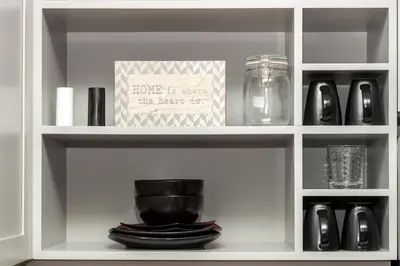 a white cabinet with a shelf with dishes and a box at Pet Friendly 2 Bedroom and 2 Bathroom Apartment near Rittenhouse apts in Philadelphia