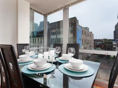 a dining room with a table with plates and wine glasses at Pet Friendly 2 Bedroom and 2 Bathroom Apartment near Rittenhouse apts in Philadelphia