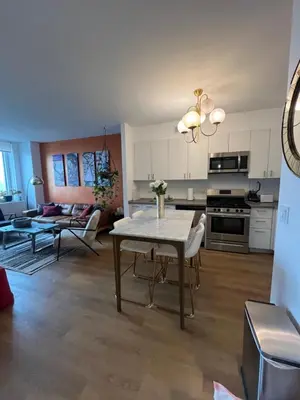 a kitchen and living room with a table and a couch at LES is MORE stunning views in New York