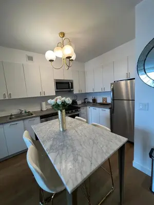 a kitchen with a table with a vase of flowers on it at LES is MORE stunning views in New York