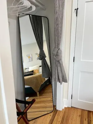a mirror in front of a room with a couch at Modern + Airy Fishtown Townhouse w/ Arcade in Philadelphia