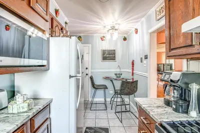 a kitchen with a white refrigerator and a table at Quaint Lansdowne Getaway Near Downtown Philly! in Lansdowne