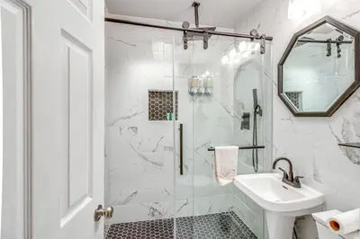 a white bathroom with a shower and a sink at Quaint Lansdowne Getaway Near Downtown Philly! in Lansdowne