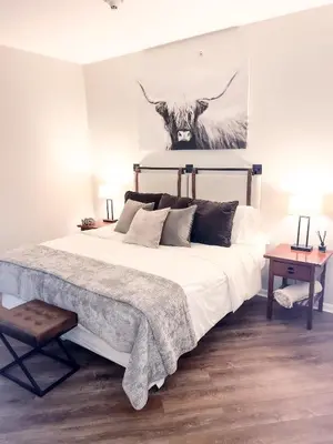 a bedroom with a bed with a cow painting on the wall at Cozy Mountain View Condo in Vernon Township