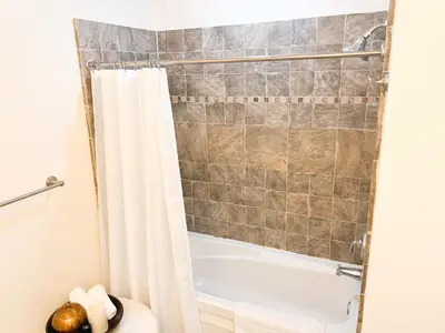 a bathroom with a tub and a shower curtain at Cozy Mountain View Condo in Vernon Township