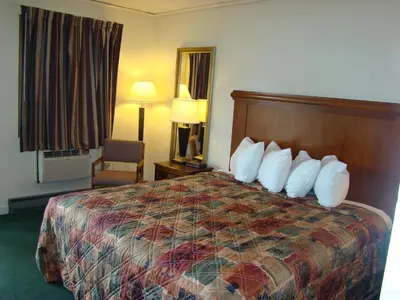 a hotel room with a bed with white pillows at Aderi Hotel Lewisburg in Lewisburg