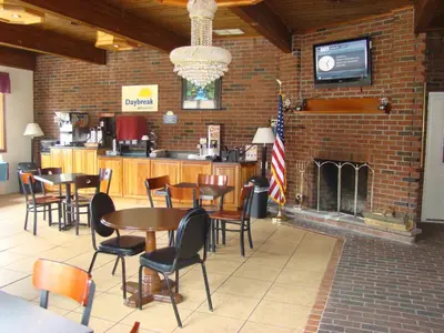a restaurant with tables and chairs and a fireplace at Aderi Hotel Lewisburg in Lewisburg