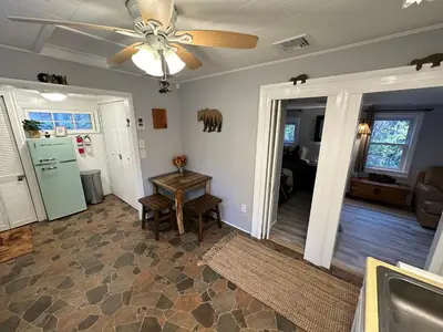 a living room with a ceiling fan and a table at Escape to a Streamside Cabin in the Lower Catskills in Wurtsboro
