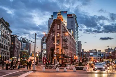 a building with a statue on top of it on a city street at STUDIOPLUS by JGSTAY, Midtown ESB in New York