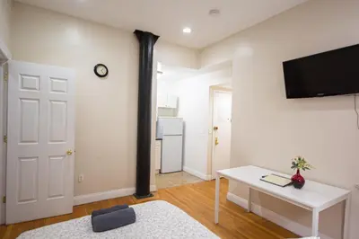a living room with a tv on a wall at STUDIOPLUS by JGSTAY, Midtown ESB in New York