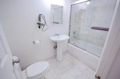 a bathroom with a toilet and a sink and a shower at STUDIOPLUS by JGSTAY, Midtown ESB in New York