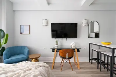a living room with a desk and a blue chair at 73-1204 New Studio UWS Doorman Gym in New York