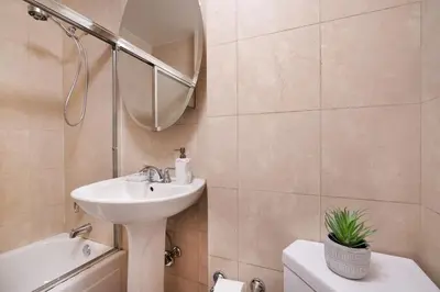 a bathroom with a sink and a toilet and a mirror at 73-1204 New Studio UWS Doorman Gym in New York