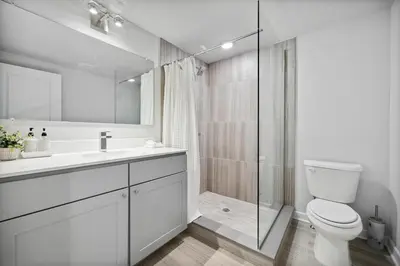 a white bathroom with a toilet and a shower at Luxurious Condo with Rooftop and Parking near University City in Philadelphia