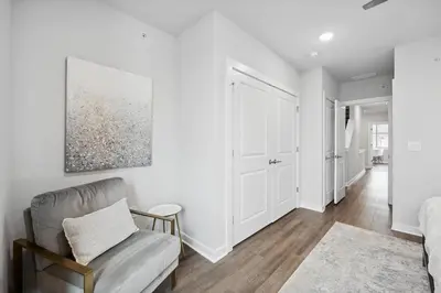 a bedroom with white walls and a chair and a couch at Luxurious Condo with Rooftop and Parking near University City in Philadelphia
