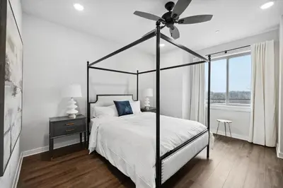 a bedroom with a black canopy bed with a ceiling fan at Luxurious Condo with Rooftop and Parking near University City in Philadelphia