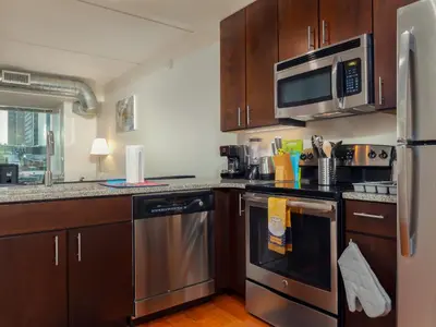 a kitchen with stainless steel appliances and wooden cabinets at Cozy Fully Furnished 2 Bedroom 2 Bathroom Apartment apts in Philadelphia