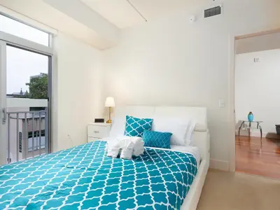 a bedroom with a bed with a blue comforter at Cozy Fully Furnished 2 Bedroom 2 Bathroom Apartment apts in Philadelphia